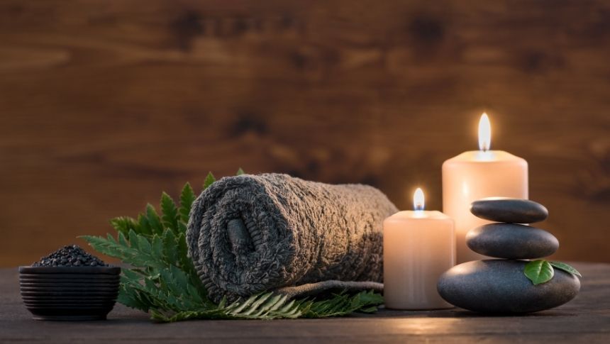 A display featuring a towel, candles and stones. hot stone massage therapy - watertown wi